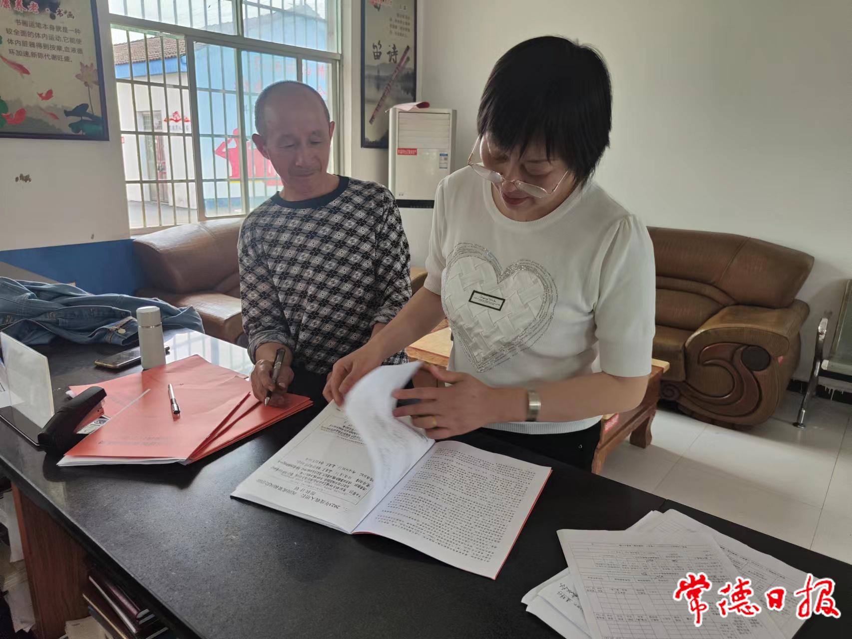 车溪河社区帮扶责任人聂辉珍（右）向聂双林（左）宣传他们户所享受的政策.jpg